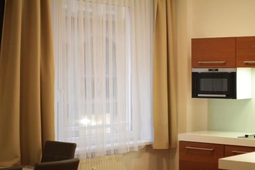 a kitchen with a window with curtains and a chair at Home Sweet Home - Stephansdom II in Vienna