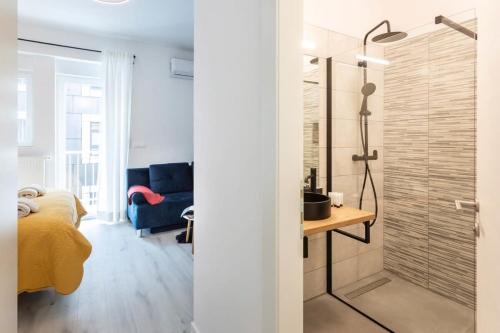 a bathroom with a glass shower and a bedroom at Lux Nest Extra City Apartment URBAN STAY in Zagreb