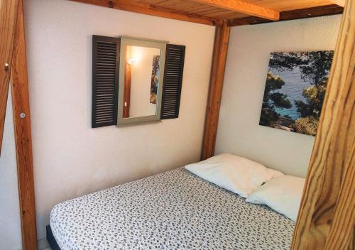 - une chambre avec un lit à baldaquin et un miroir dans l'établissement Mazet - à 300m de la plage / Terrasse / Wifi / La Conciergerie Varoise, à La Londe-les-Maures