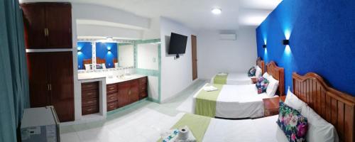- une chambre avec un lit, un lavabo et un miroir dans l'établissement Hotel Capri Playa a una calle de la Playa Regatas, à Veracruz