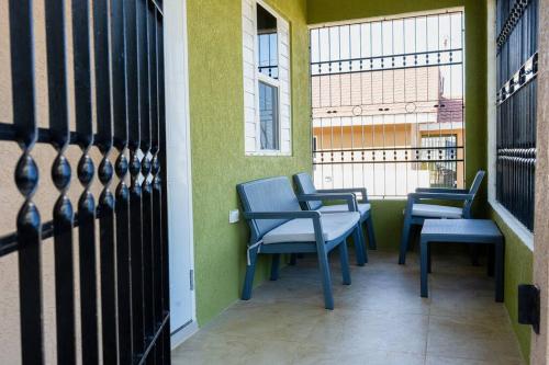 una fila de sillas y mesas en un balcón en Your ideal home away from home., en The Rock