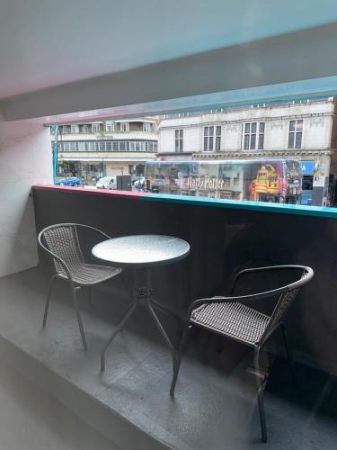 einen Tisch und zwei Stühle vor einem Fenster in der Unterkunft Central entire studio apartment in London
