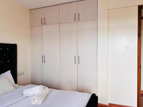 1 dormitorio con armarios blancos y 1 cama en Adjana’s Cozy apartment, en Nairobi
