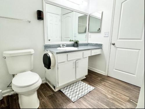 uma casa de banho branca com um WC e um lavatório em Queen Suite Home Theater WiFi 2 em Morrow