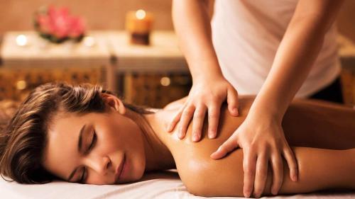 a woman getting a back massage from a therapist at The Lake - Casa Vacanza in Dormelletto