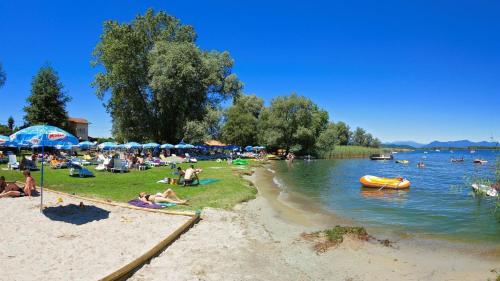 a group of people on a beach near a body of water at The Lake - Casa Vacanza in Dormelletto