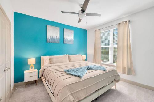 Luxury Stylish Apt in Historic Ybor City في تامبا: غرفة نوم زرقاء مع سرير وجدار ازرق