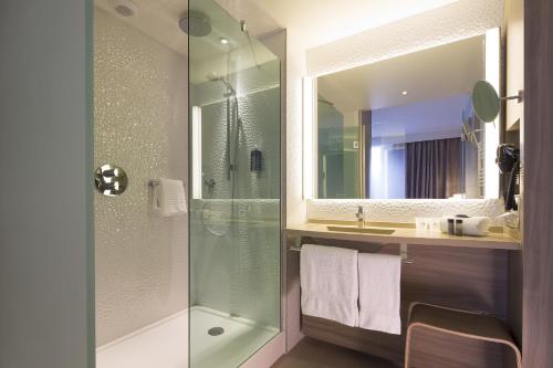 y baño con ducha acristalada y lavamanos. en Oceania Rennes, en Saint-Grégoire