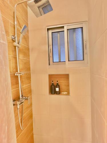 a bathroom with a shower and a window at Chez Maëlys in Douala