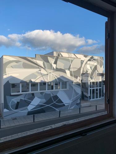 a window with a painting of a building at Habitaciones privadas cerca de la playa y aeropuerto en casa compartida con otros huéspedes in Playa Honda