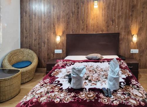 1 dormitorio con 1 cama con 2 toallas y 1 silla en Hotel Comfort Residency en Darjeeling