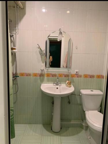 een badkamer met een wastafel, een toilet en een spiegel bij 1-комнатная квартира в Ереване in Jerevan