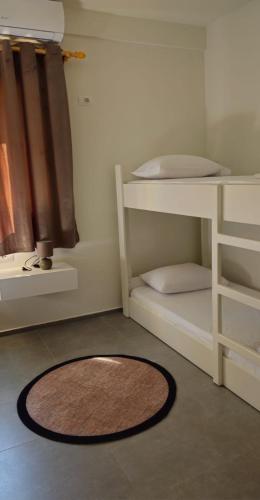 a rug on the floor in a room with bunk beds at Vacation Station sea view apartament in Vlorë