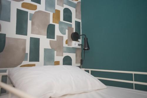 a bedroom with a bed with a geometric wall at Aerostay Hostel in Moreira