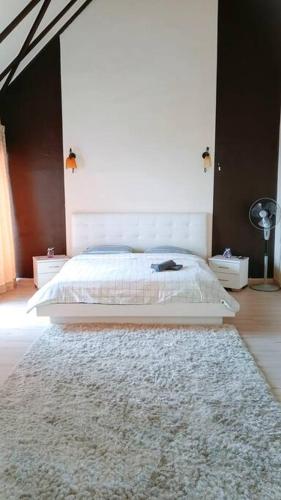 a bedroom with a white bed and a rug at Silverpart Resort Fraser Hill C3-6-2 Forest View High Floor No lift in Bukit Fraser