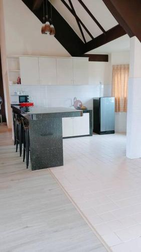 a kitchen with a black counter and a refrigerator at Silverpart Resort Fraser Hill C3-6-2 Forest View High Floor No lift in Bukit Fraser