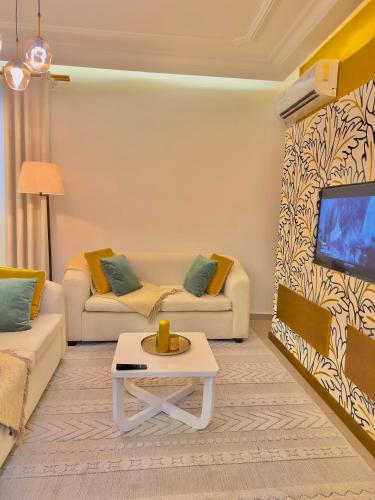 a living room with two couches and a tv at Chez Maëlys in Douala