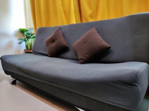 a couch with two brown pillows on it at Tamarind Suites OR Domain NeoCyber, click room first for pics in Cyberjaya