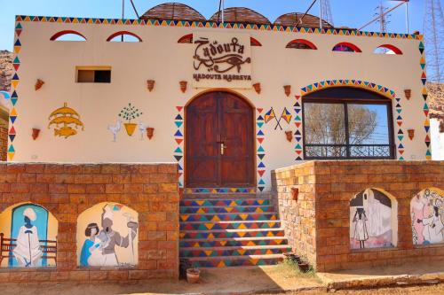 een huis geschilderd als een kerk met een deur bij Hadouta Masreya Nubian Guest House in Aswan