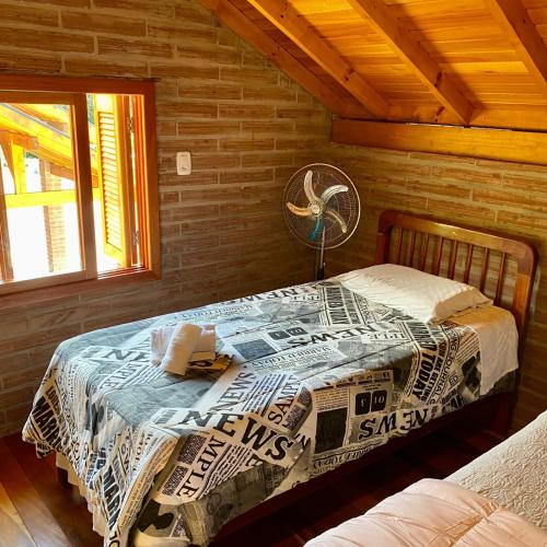 1 dormitorio con 1 cama en una cabaña de madera en Villetta Gramado Siena, en Gramado
