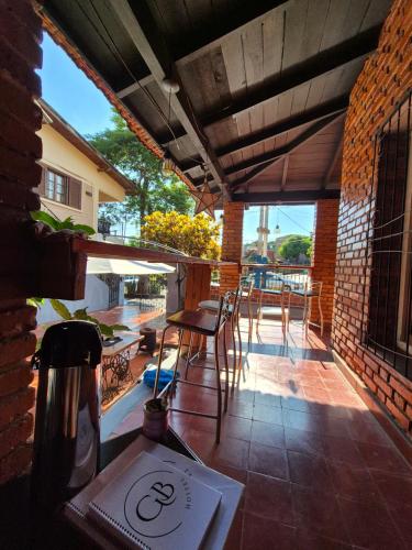 een patio met een tafel en stoelen bij GB Hostel IG in Puerto Iguazú