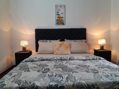a bedroom with a large bed with two lamps at OBhouse Apartment, para sentirse como en casa! in Asunción