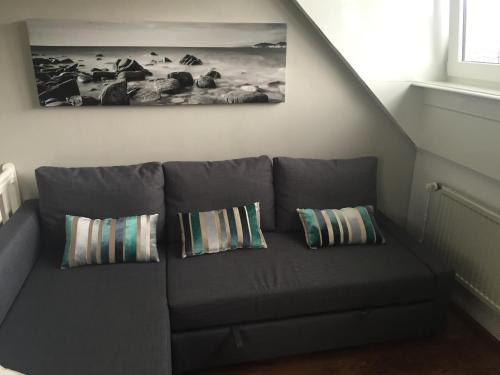 
a living room with a couch and a window at Independent Apartment Spaarne in Haarlem

