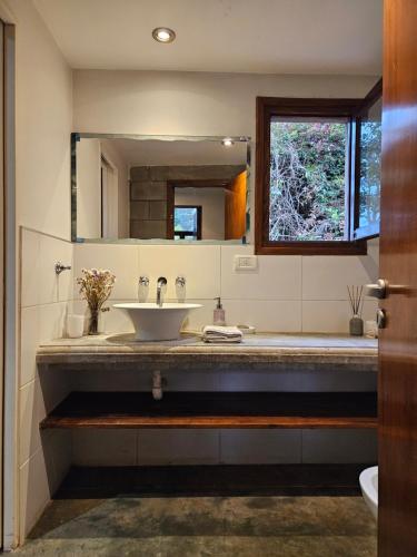 W łazience znajduje się umywalka i lustro. w obiekcie Casadebosq w mieście Mar del Plata
