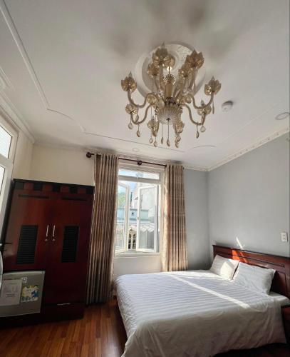 a bedroom with two beds and a chandelier at Hotel Đăng Uyên D65 in Da Lat