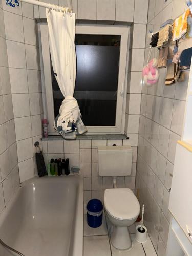 基森的住宿－Schönes Zimmer in Bahnhofsnähe in einer Wohnung mit großer Terrasse，一间带卫生间和浴缸的浴室以及窗户。