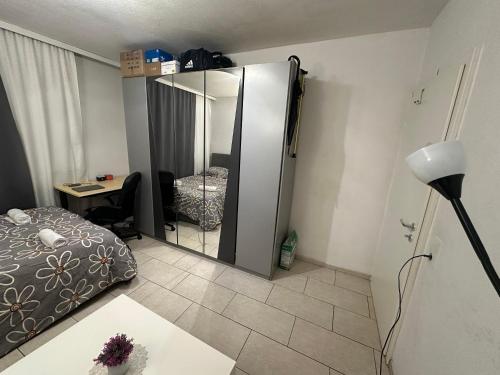1 dormitorio con espejo, cama y escritorio en Schönes Zimmer in Bahnhofsnähe in einer Wohnung mit großer Terrasse en Gießen