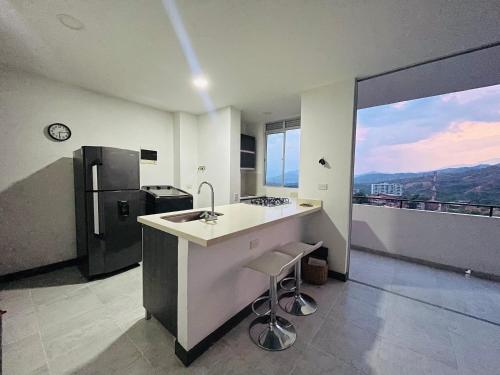 ¡Vista Increíble Apartamento Tamarindo! في سانتا في دي أنتيوكيا: مطبخ مع مغسلة وثلاجة