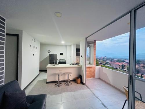 a kitchen and living room with a view of a city at ¡Vista Increíble Apartamento Tamarindo! in Santa Fe de Antioquia