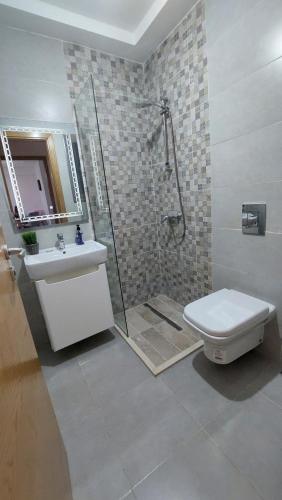 a bathroom with a shower and a toilet and a sink at Apparemment calm a Aouina in La Soukra