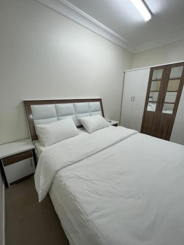 1 dormitorio con 1 cama blanca grande y 2 almohadas en Studio - غرفة استوديو بالدور 2, en Al Rass