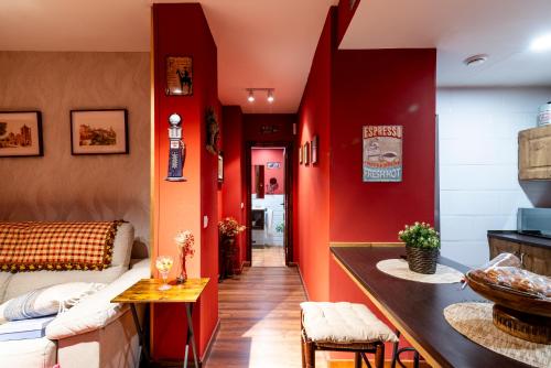 a living room with red walls and a couch at Apartamento Mikaela Alcalá de Henares in Alcalá de Henares