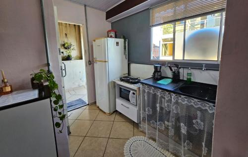 a small kitchen with a refrigerator and a sink at Kitnet Completa em Osasco Facil acesso ao Rodoanel in Osasco