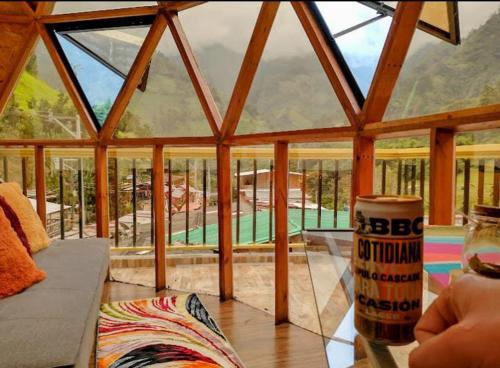 a glass room with a view of a house at Glamping Ibanazk in Ibagué