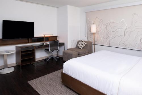 a hotel room with a bed and a desk with a television at Element Lexington in Lexington
