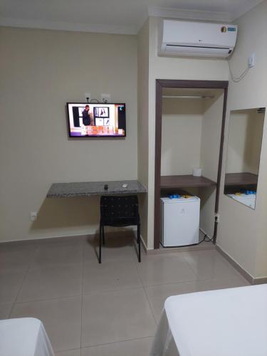 a living room with a tv on the wall at Apoema Hotel in Cuiabá