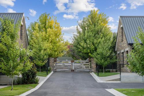a driveway between two buildings with trees at Vale 194 - Luxury Accommodation in McLaren Vale - 5 holiday homes with king size beds in McLaren Vale