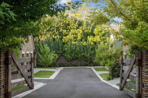 an entrance to a driveway with a gate and trees at Vale 194 - Luxury Accommodation in McLaren Vale - 5 holiday homes with king size beds in McLaren Vale