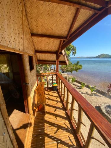 Ocamocam Beach Martins في New Busuanga: شرفة منزل مطلة على الماء