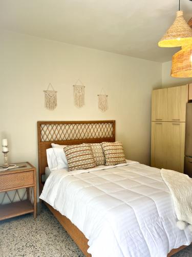 a bedroom with a large white bed and a table at Villa Bamboo in San Juan