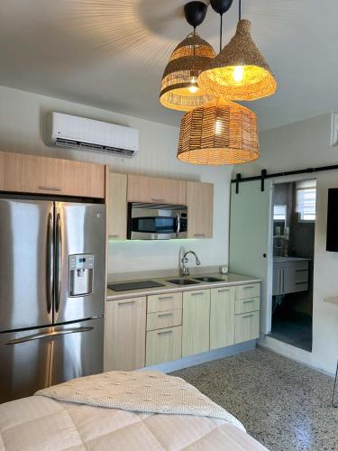 a kitchen with a stainless steel refrigerator and pendant lights at Villa Bamboo in San Juan