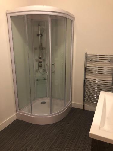 a shower with a glass enclosure in a bathroom at Dunfermline High Street Flat Ideal For Edinburgh& St. Andrews in Dunfermline