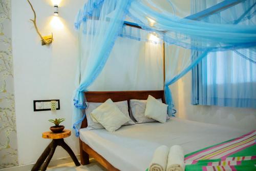 1 dormitorio con 1 cama con cortinas azules en New Cormorant Lake Resort & Yala Safari Place en Tissamaharama