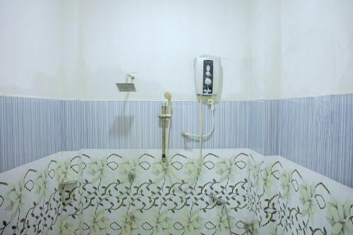 a shower in a bathroom with a shower curtain at New Cormorant Lake Resort & Yala Safari Place in Tissamaharama