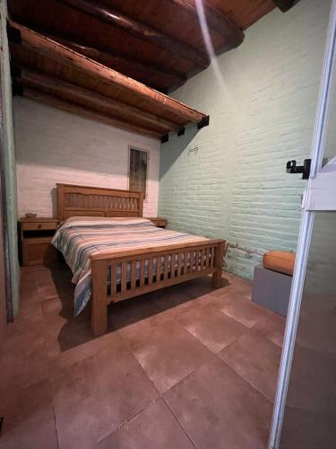 a bedroom with a wooden bed in a room at Tu rincón la travesia in Las Compuertas