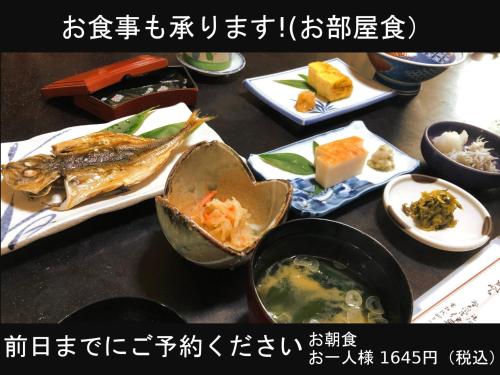 una tabella ricoperta con diversi tipi di alimenti su piatti di Izuya Ryokan - Vacation STAY 22369v a Yugawara